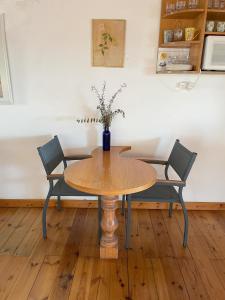 a table with two chairs and a vase with flowers on it at Nof Harim נוף הרים in Even Menahem