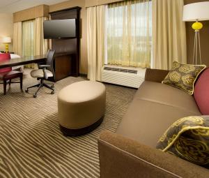 - un salon avec un canapé et un bureau dans une chambre d'hôtel dans l'établissement Hampton Inn & Suites Chattanooga/Hamilton Place, à Chattanooga