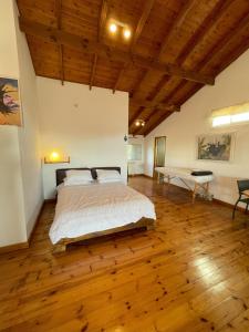 una grande camera da letto con un letto e un pavimento in legno di Nof Harim נוף הרים a Even Menahem