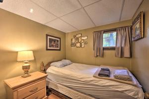 ein Schlafzimmer mit einem Bett, einer Lampe und einem Fenster in der Unterkunft Lone Ranger Cabin with 50 Acres by Raystown Lake in Huntingdon