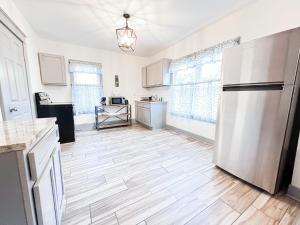 a kitchen with a white refrigerator in a room at The Trotter Manor- With Private Yard & Free Parking, Minutes From Falls & Casino by Niagara Hospital in Niagara Falls