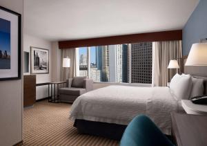 a hotel room with a bed and a chair and a window at Hampton Inn Chicago Downtown/Magnificent Mile in Chicago +21 photos