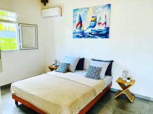sypialnia z łóżkiem i obrazem na ścianie w obiekcie Vanille, à proximité des plages, idéalement situé pour visiter la Guadeloupe w mieście Le Gosier