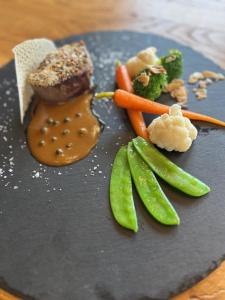 un plato de comida con carne y verduras en una mesa en Landgasthaus Lenniger en Büren