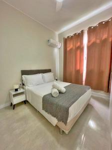 ein Schlafzimmer mit einem großen weißen Bett und einem Fenster in der Unterkunft Copacabana Posto 6 in Rio de Janeiro