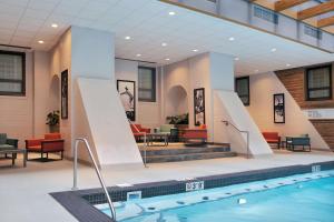 una piscina en un hotel con sillas y mesas en The Palmer House Hilton, en Chicago