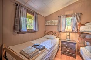 a bedroom with two beds and a lamp and two windows at Wyatt Earp Cabin with Deck, 1 Mi to Raystown Lake! in Huntingdon