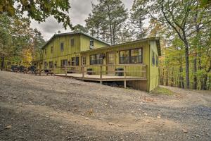 a green house in the middle of the forest at Wyatt Earp Cabin with Deck, 1 Mi to Raystown Lake! in Huntingdon
