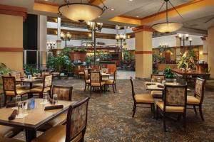 a restaurant with tables and chairs in a room at Embassy Suites North Charleston Airport Hotel Convention in Charleston
