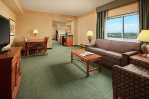 チャールストンにあるEmbassy Suites North Charleston Airport Hotel Conventionのソファとテーブル付きのホテルルーム