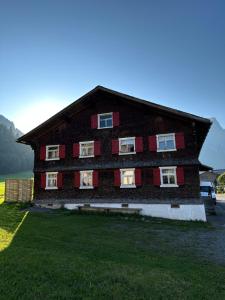 a large wooden house with red shutters at Great old WÄLDERHAUS in Au im Bregenzerwald