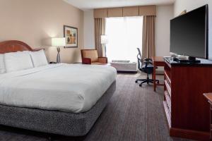 a hotel room with a bed and a flat screen tv at Hilton Garden Inn Charlotte North in Charlotte