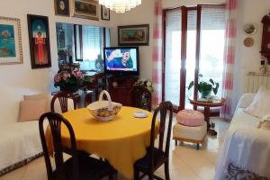 a living room with a yellow table and a tv at Casamia. Confortevole appartamento vicinissimo al mare in Porto Torres