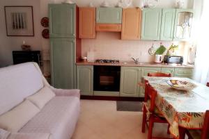 y cocina con mesa, sofá y mesa. en Casamia. Confortevole appartamento vicinissimo al mare en Porto Torres