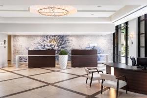 a lobby with a reception desk and a table and chairs at Victoria Marriott Inner Harbour in Victoria