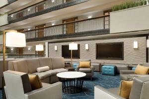 a hotel lobby with couches and a flat screen tv at Embassy Suites by Hilton Columbus in Columbus