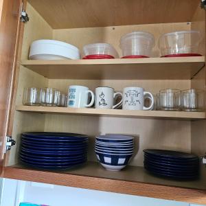 a shelf filled with plates and cups and bowls at Relaxing Stay Near the Beach in Hampton
