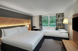a hotel room with two beds and a window at Hilton Cobham in Cobham