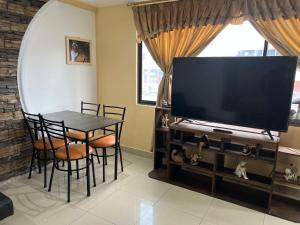 a dining room with a table and a large television at Hermoso y acogedor departamento in Atuntaqui