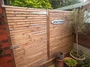 a wooden privacy fence with a sign that readserrormary at Airport Hideaway in Manchester