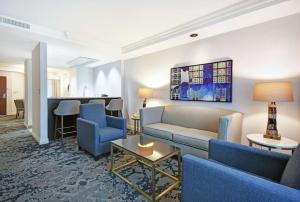 uma sala de estar com um sofá, cadeiras e uma mesa em Embassy Suites Charleston em Charleston