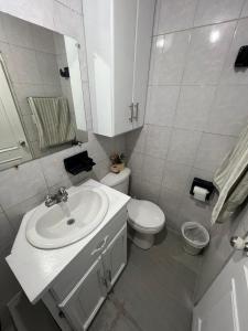 bagno bianco con lavandino e servizi igienici di Hermoso y acogedor departamento a Atuntaqui