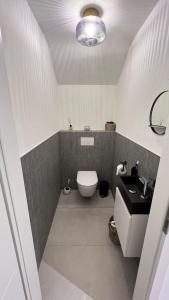 uma casa de banho com um WC branco e um lavatório. em La Pacha, chambre d'hôtes em Spa