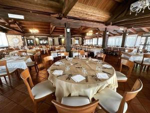 une grande salle à manger avec des tables et des chaises blanches dans l'établissement Agriturismo Cervinace, à Oriolo