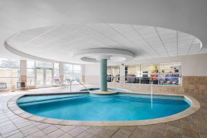 a swimming pool in a hotel lobby with a large ceiling at Hilton Garden Inn Dallas Richardson in Richardson