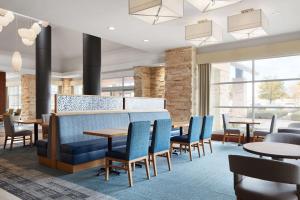 um restaurante com cadeiras e mesas azuis e janelas em Hilton Garden Inn Dallas Richardson em Richardson
