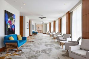 a hallway with chairs and couches in a building at Hilton Garden Inn Dallas Richardson in Richardson