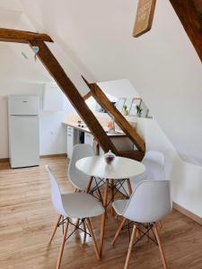ein weißes Esszimmer mit einem Tisch und Stühlen in der Unterkunft Appartement 4 personnes in Nesle