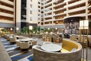 a restaurant with tables and chairs in a building at Embassy Suites Dallas - DFW Airport North in Grapevine