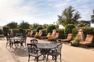 a group of tables and chairs sitting on a patio at Embassy Suites Dallas - DFW Airport North in Grapevine