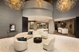 a lobby with white furniture and chandeliers at Embassy Suites Dallas - DFW Airport North in Grapevine