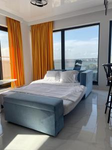 a large bed in a room with large windows at Shiba studio Mamaia in Mamaia