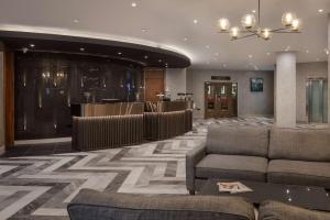 a lobby with couches and a bar in a building at Hilton Cardiff in Cardiff