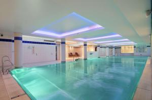 an empty swimming pool in a large room with a pool at Hilton Cardiff in Cardiff