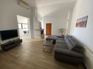 ein Wohnzimmer mit einem Sofa und einem Flachbild-TV in der Unterkunft Sunset Villa Brela in Brela