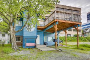 a blue house with a deck on top of it at Rustic Anchorage Hideaway Walk to Coastal Trail! in Anchorage