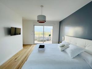 1 dormitorio con 1 cama blanca grande y ventana grande en résidence belle vue, en Fontaine-le-Port