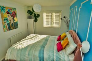 sypialnia z łóżkiem z kolorowymi poduszkami w obiekcie Duchess of Cambridge w mieście Copdock