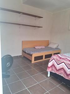 a bedroom with a bed and a chair in it at Loft Praia do Sonho in Itanhaém