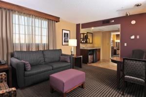 a living room with a couch and a table at Embassy Suites Des Moines Downtown in Des Moines