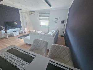 a living room with a couch and a table and chairs at Apartman Samantha in Vinkovci