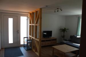 een woonkamer met een bank, een tv en een tafel bij Ferienwohnung Feldblick in Struppen