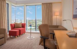 a hotel room with a living room with a large window at Hilton Dublin Airport in Cloghran