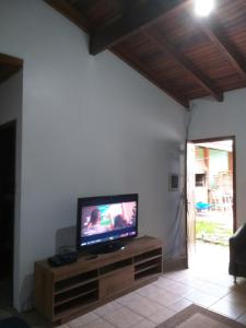 uma sala de estar com uma televisão de ecrã plano num centro de entretenimento em madeira em Casa no Parque em Canoas