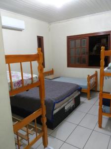 sypialnia z 2 łóżkami piętrowymi i telewizorem w obiekcie Casa no Parque w mieście Canoas