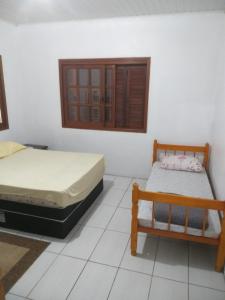 um quarto com duas camas e um banco em Casa no Parque em Canoas
